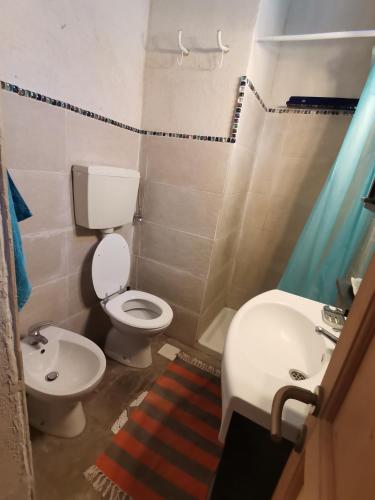 a small bathroom with a toilet and a sink at Trulli Vittoria in Putignano