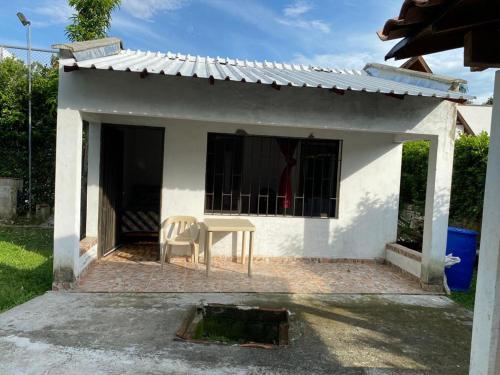 une petite maison blanche avec une table et une chaise dans l'établissement Finca del profe, à Santa Fe de Antioquia