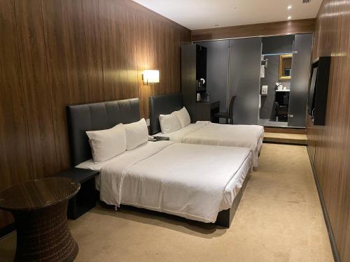 pokój hotelowy z 2 łóżkami i stołem w obiekcie Water meworld w Tajpej