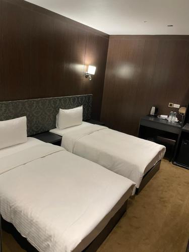 a hotel room with two beds and a desk at Water meworld in Taipei