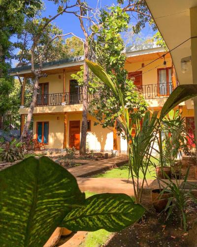 a large yellow house with plants in front of it at Casa Inti Guesthouse & Lodge in Managua