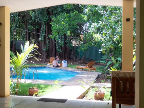 a person sitting by a pool in a yard at Casa Inti Guesthouse & Lodge in Managua