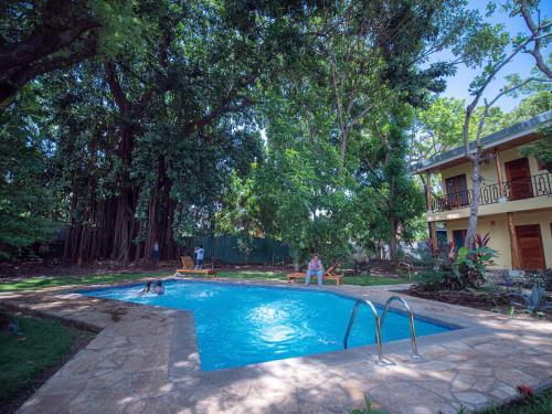 a swimming pool with two people in it next to a house at Casa Inti Guesthouse & Lodge in Managua