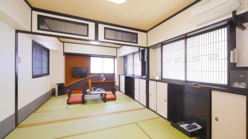 Habitación grande con mesa y algunas ventanas. en Hotel Chatelet Inn Kyoto en Kioto