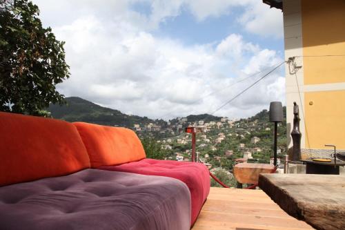 a couch sitting on a balcony with a view of a city at BBQ Lodge in Camogli