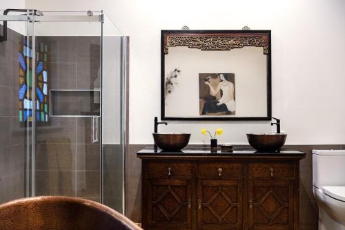 a bathroom with a shower and two bowls on a wooden cabinet at Musk Manor Cottage in Bullarto