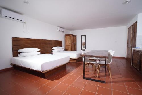 a bedroom with two beds and a table and a table and chairs at Playa Esperanza Resort in Celestino Gasca