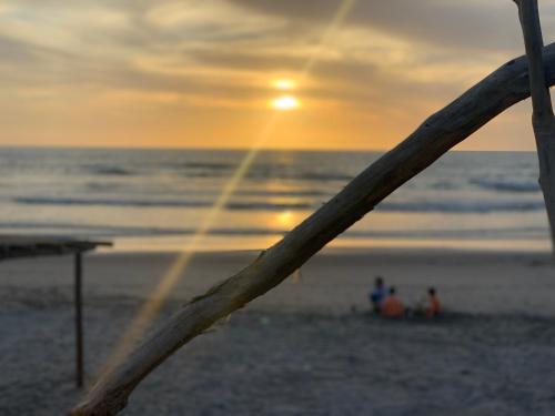 a group of people on the beach at sunset at Playa Esperanza Resort in Celestino Gasca
