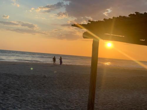 two people walking on the beach at sunset at Playa Esperanza Resort in Celestino Gasca