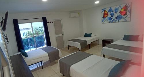 Cette chambre comprend 2 lits et une fenêtre. dans l'établissement Hotel La Inmaculada, à Soledad