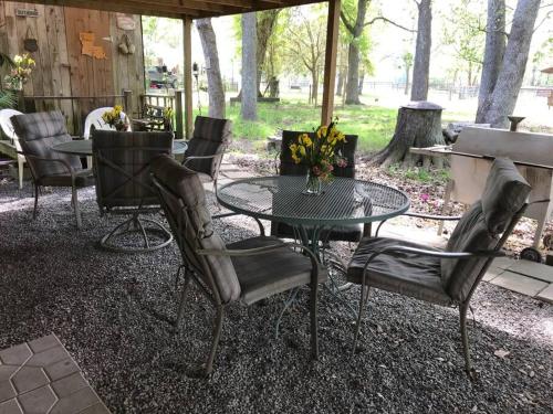 un patio con una mesa y sillas con flores. en La Maison du Bayou Petite Anse, en New Iberia
