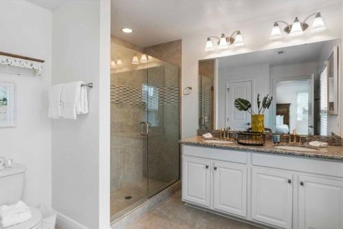 a white bathroom with a shower and a sink at Beautiful 4 bedroom near Rosemary Beach! in Inlet Beach