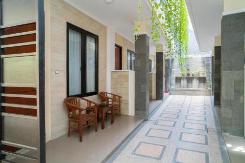 a corridor of a building with a table and chairs at RedDoorz Plus Syariah @ Jalan Dokter Wahidin Bojonegoro in Bojonegoro