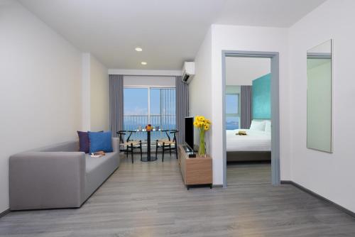 a living room with a couch and a table at Centre Point Prime Hotel Pattaya in Pattaya North