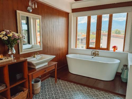 a bathroom with a large tub and a sink at Pai Cherkaew Boutique House in Pai