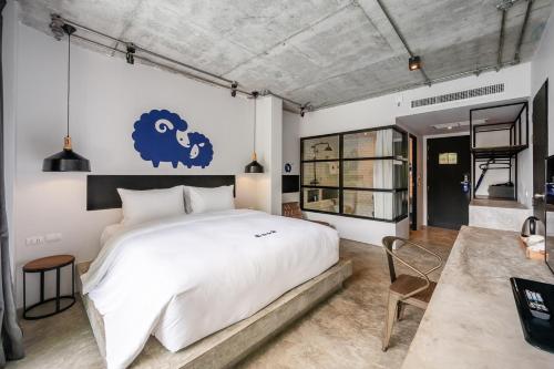1 dormitorio con 1 cama grande y un cartel azul en la pared en Kokotel Khao Lak Lighthouse - SHA Extra Plus en Khao Lak