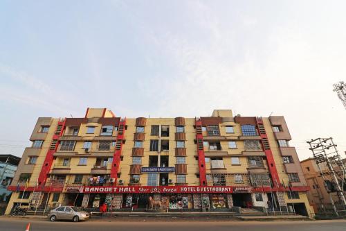 a large building with a car parked in front of it at Hotel O Sher E Bengal in Durgāpur
