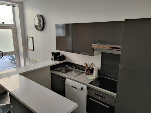 une cuisine avec un évier et un plan de travail dans l'établissement Le Havre, 1 chambre , appartement Sympa en centre ville, au Havre