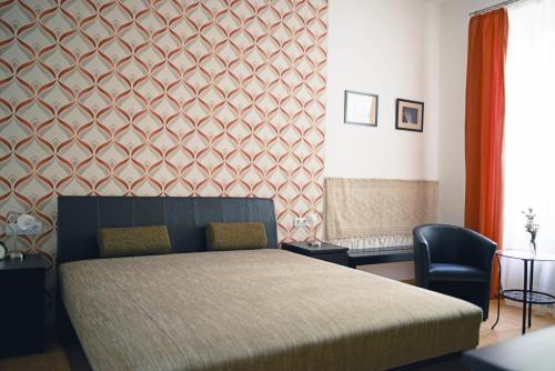 ein Schlafzimmer mit einem Bett und einem Stuhl in der Unterkunft Louisa Apartment in Budapest