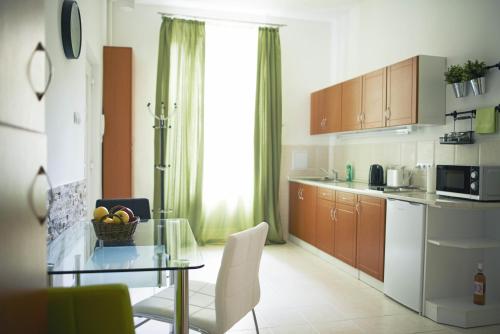 eine Küche mit einem Glastisch und einem Esszimmer in der Unterkunft Louisa Apartment in Budapest