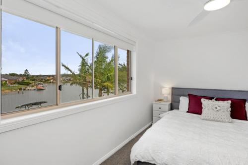 a bedroom with a bed and a large window at Pelican Waters in Sussex inlet