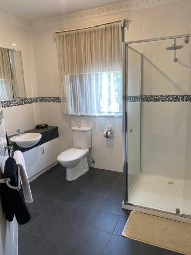 a bathroom with a shower and a toilet and a sink at 503 On Princes Drive Motel in Morwell