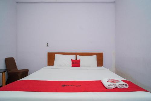 a bedroom with a bed with two towels on it at RedDoorz Plus Syariah At Lotus Hotel Bojonegoro in Bojonegoro