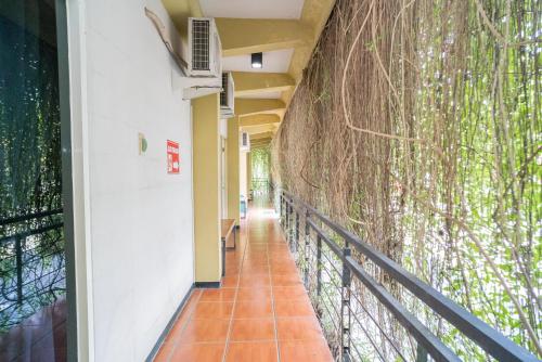 a corridor of a building with a tree mural on the wall at RedDoorz Plus Syariah At Lotus Hotel Bojonegoro in Bojonegoro