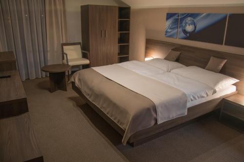 a bedroom with a large bed and a table and a chair at Restaurace a Penzion U Klásků in Olomouc