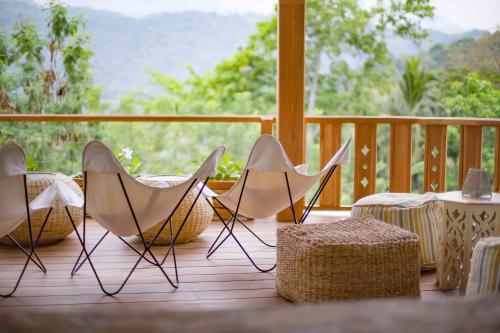 three chairs and a table on a porch with a view at Rukgala Retreat in Digana