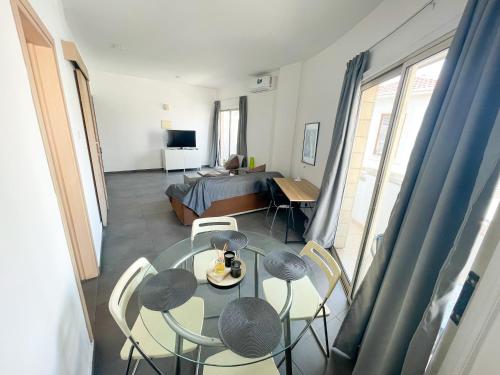 a living room with a table and chairs and a bed at High Speed Holiday Apartment in Larnaca