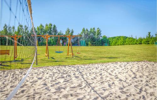 a volley ball net in a field with a playground at 2 Bedroom Awesome Home In Jaroslawiec in Jarosławiec