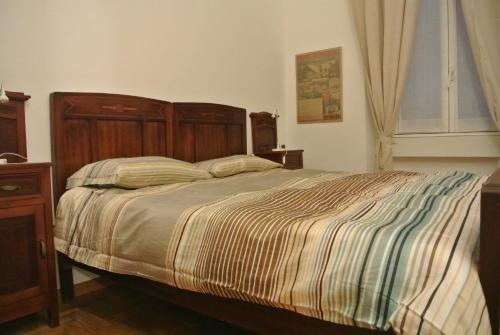 - une chambre avec un grand lit et une tête de lit en bois dans l'établissement Studio Errepì Loreto, à Milan