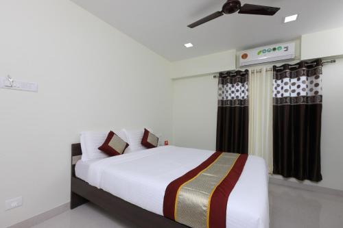 een slaapkamer met een bed en een plafondventilator bij Perfect Stay Near Meenambakkam Metro Station in Chennai