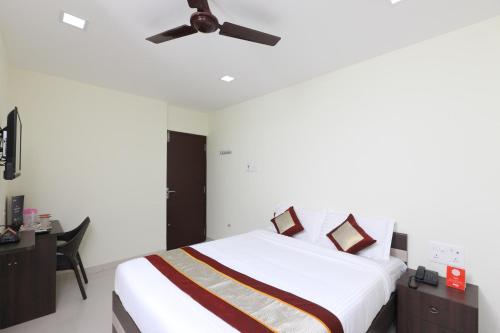 a bedroom with a bed and a ceiling fan at Super Hotel O Perfect Stay Near Meenambakkam Metro Station in Chennai