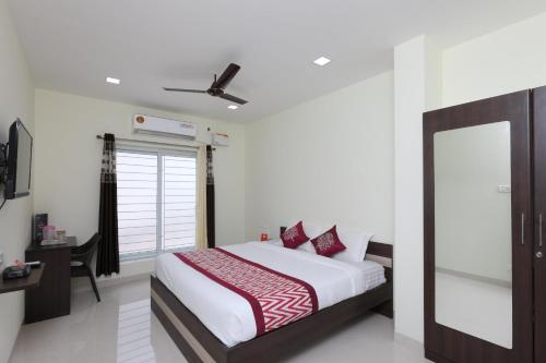 een slaapkamer met een bed en een spiegel bij Perfect Stay Near Meenambakkam Metro Station in Chennai