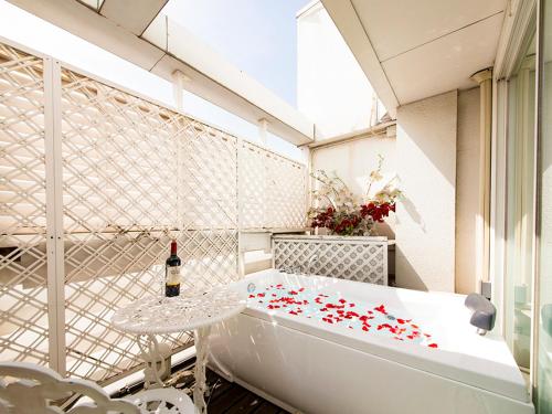 una vasca da bagno con tavolo e una bottiglia di vino di V Hotel (Adult Only) a Kobe