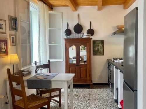 cocina con mesa, nevera y encimera en Ca' dei Merli - charming Italian village house, en Degna
