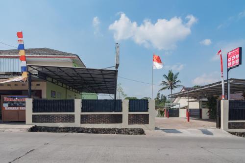 un bâtiment doté d'une clôture blanche et d'un drapeau dans l'établissement RedDoorz Syariah near Tugu Pandanwangi Cianjur, 