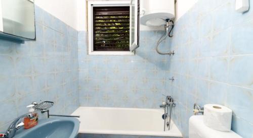 uma casa de banho com um lavatório, uma banheira e uma janela em Apartments by the sea Prozurska Luka, Mljet - 617 em Maranovići