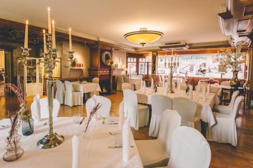 um salão de banquetes com mesas brancas e cadeiras brancas em Hotel Gasthaus Appel Krug em Delbrück