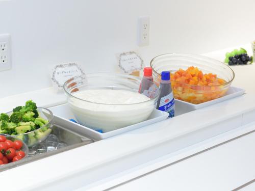 a refrigerator shelf filled with vegetables and other food items at Hotel Abest Grande Okayama in Okayama