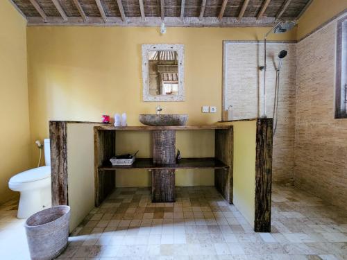 een badkamer met een wastafel en een toilet bij Bamboo Lodge in Gili Trawangan