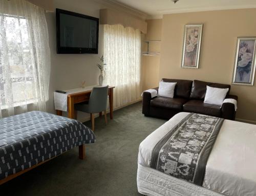 een hotelkamer met een bed en een bank bij 503 On Princes Drive Motel in Morwell