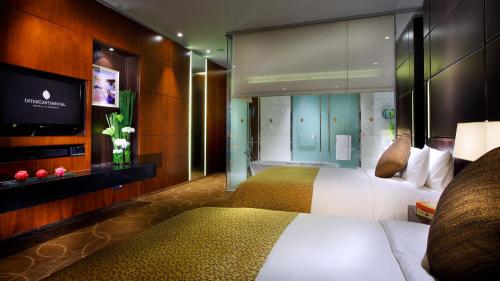 a hotel room with a bed and a flat screen tv at InterContinental Nanjing by IHG in Nanjing