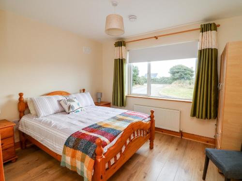 sypialnia z łóżkiem i dużym oknem w obiekcie High Meadow House w mieście Duncormick
