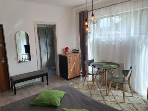 ein Schlafzimmer mit einem Tisch und ein Zimmer mit einem Bett in der Unterkunft AOSTA VALLEY SINAIA in Sinaia