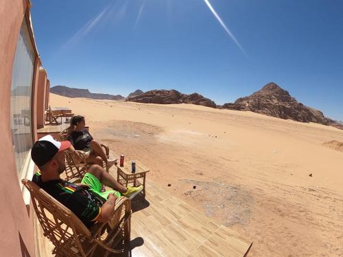 two young boys sitting on chairs on the beach at Rum Jordan camp and tours in Wadi Rum