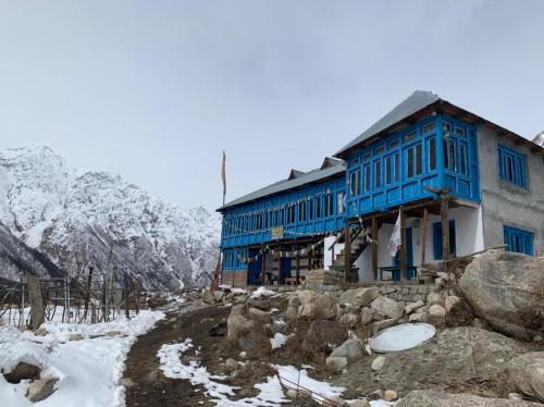 a blue and white building with snow on the ground at NotOnMap - Adobe The Cloud in Chitkul