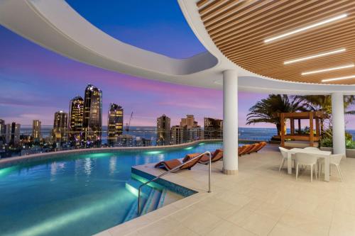 a swimming pool with a city skyline in the background at The Gallery Residences Broadbeach in Gold Coast